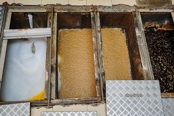 foul smells, slow drainage, and visible grease accumulation are all indicators that a grease trap is due for maintenance